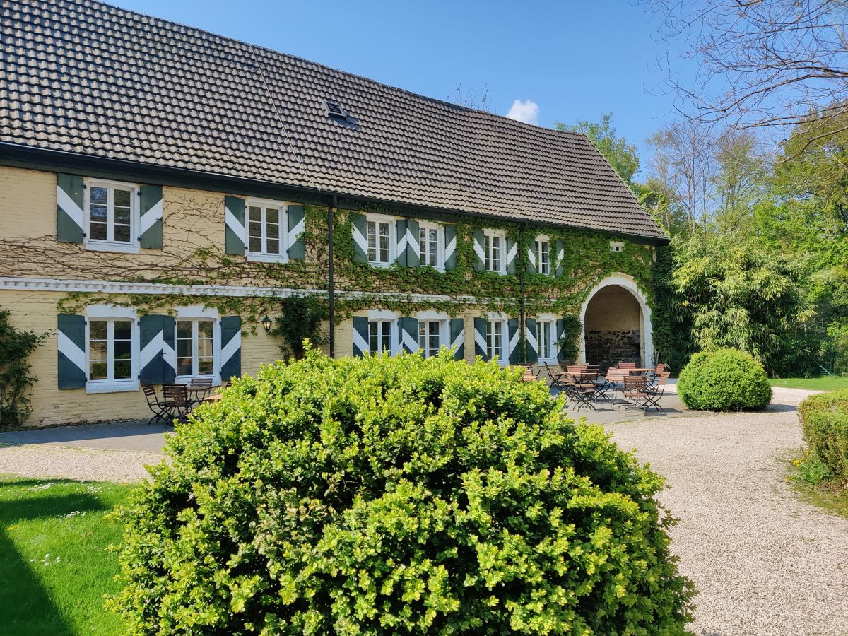 Efeuberankte Fassade der Wasserburg Haus Graven mit dem Burgcafé